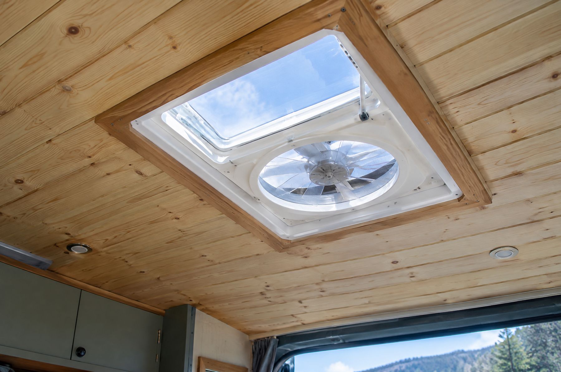 Roof fan in a pine ceiling with a trim ring
