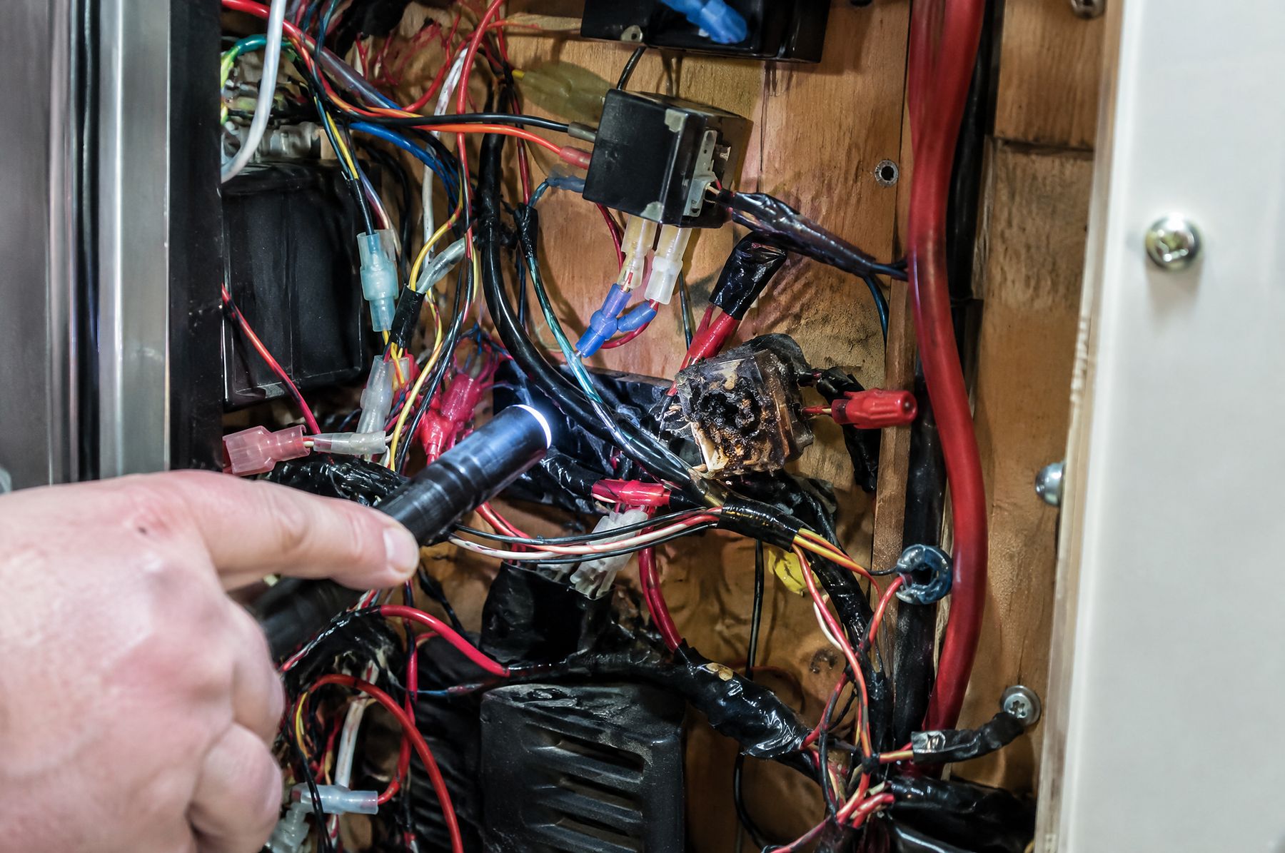 Undersized wire and a melted connector behind a panel
