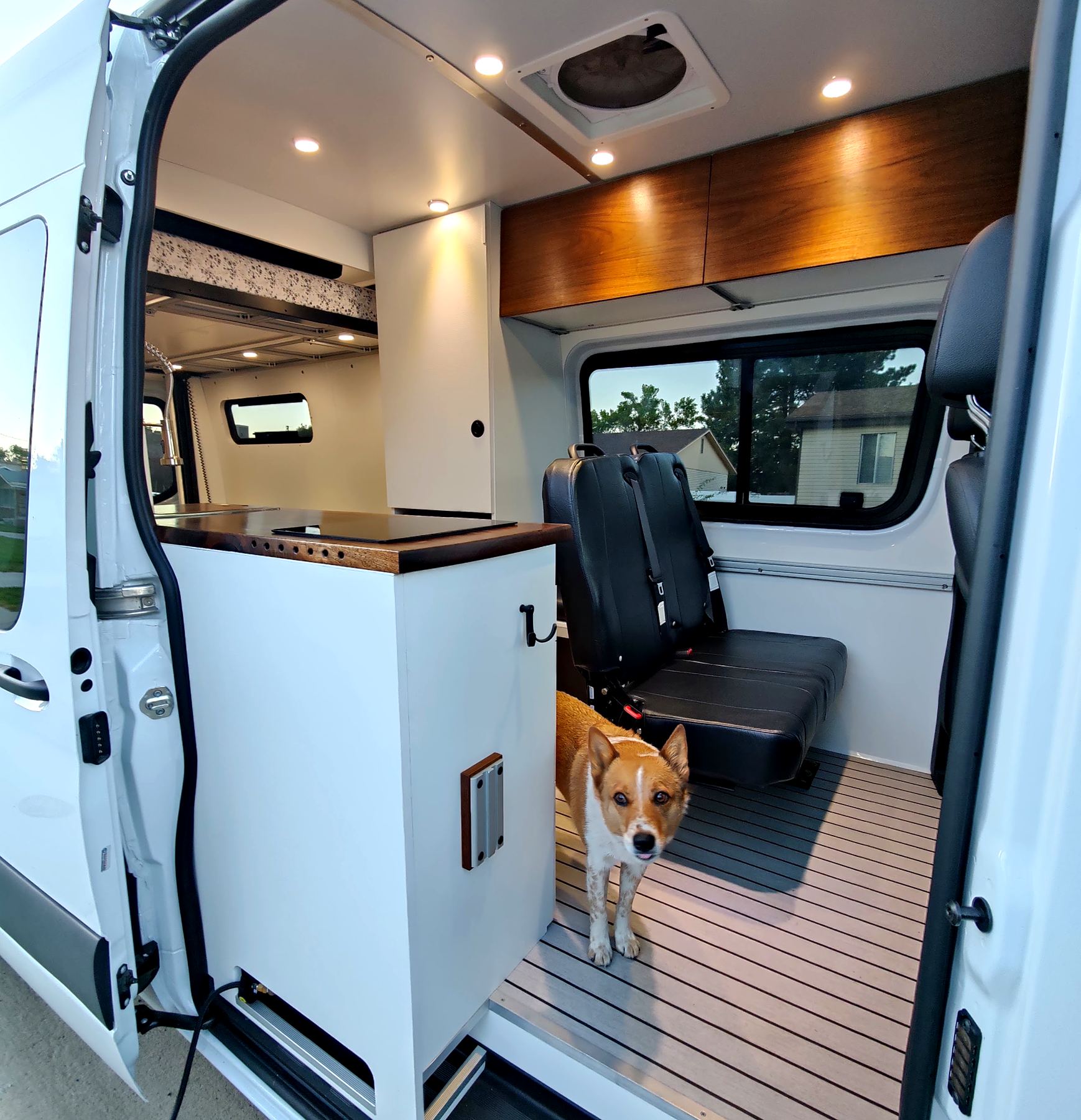 Swivel passenger seat and cabinetry in a white van interior