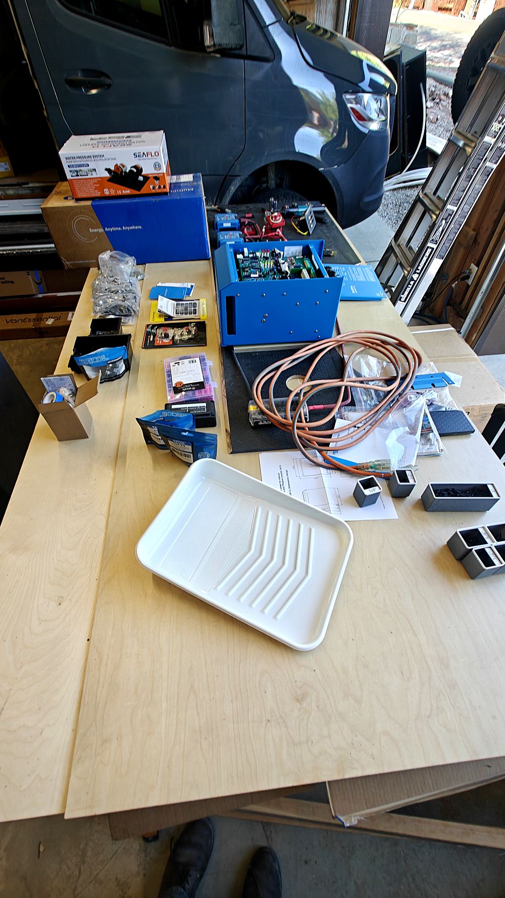 Electrical components laid out on the shop bench before a van install
