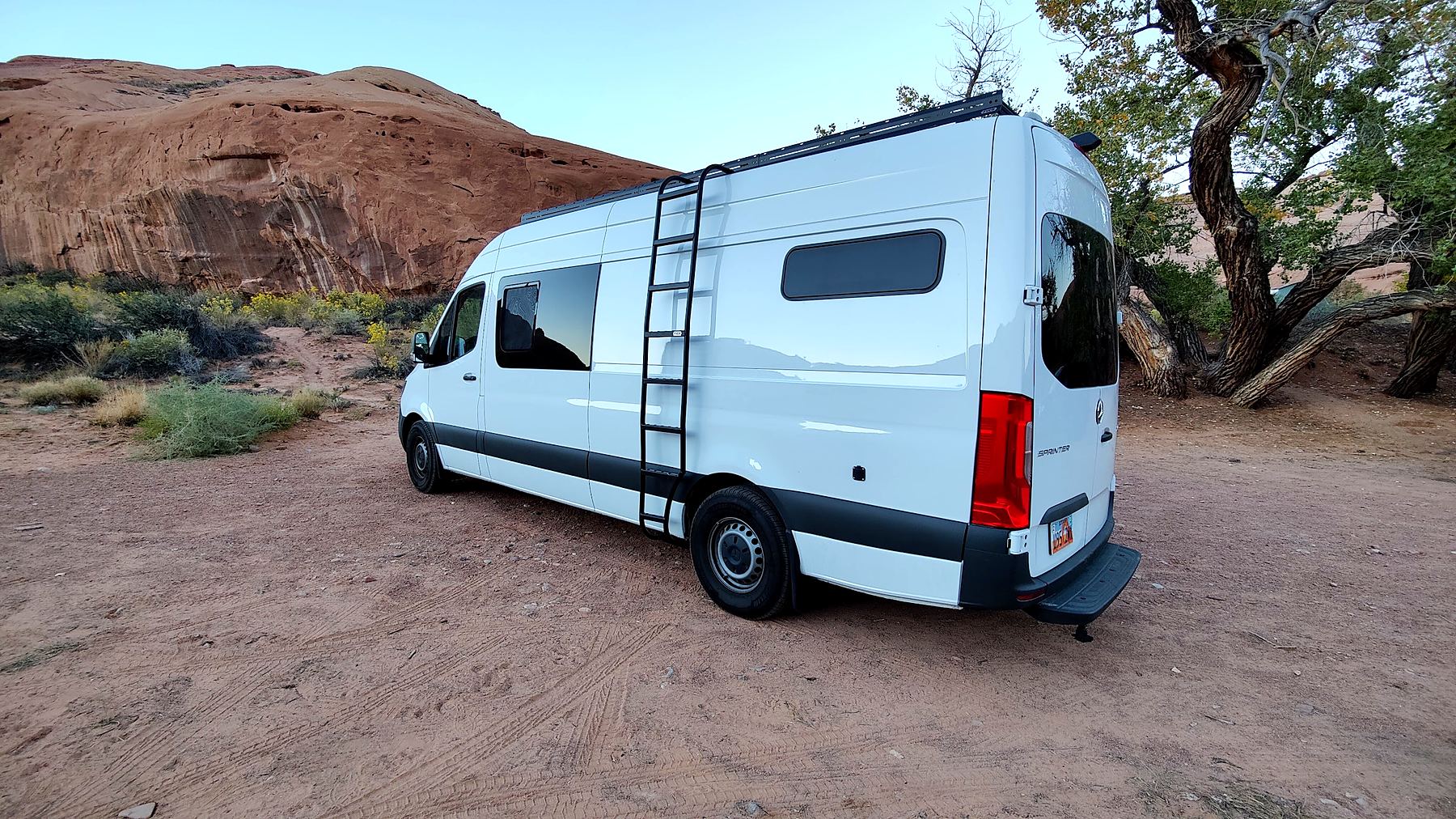 Alt Life Vans Sprinter conversion with ladder and windows parked in the Utah desert