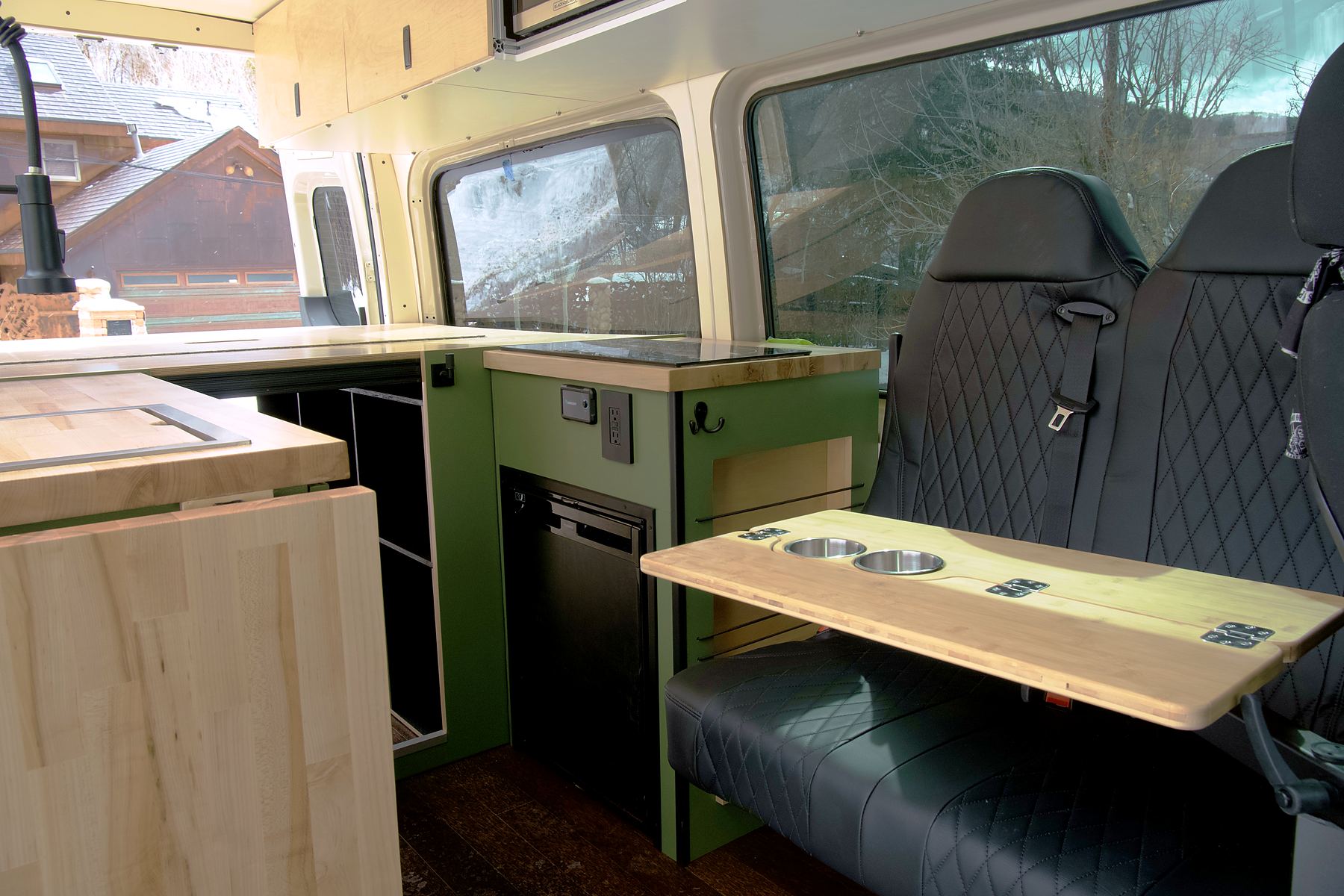 Custom Sprinter interior with maple cabinets, sage green galley and a dinette bench